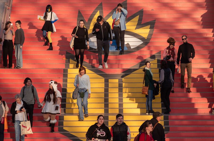 Menschen auf einer Treppe mit dem Logo der Buchmesse