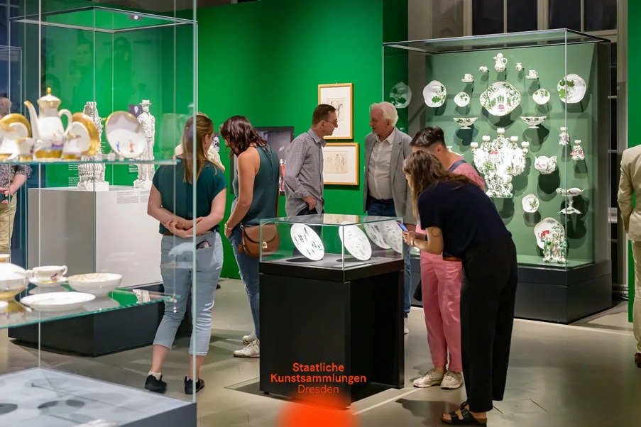 Blick in eine Ausstellung mit Vitrinen und Menschen