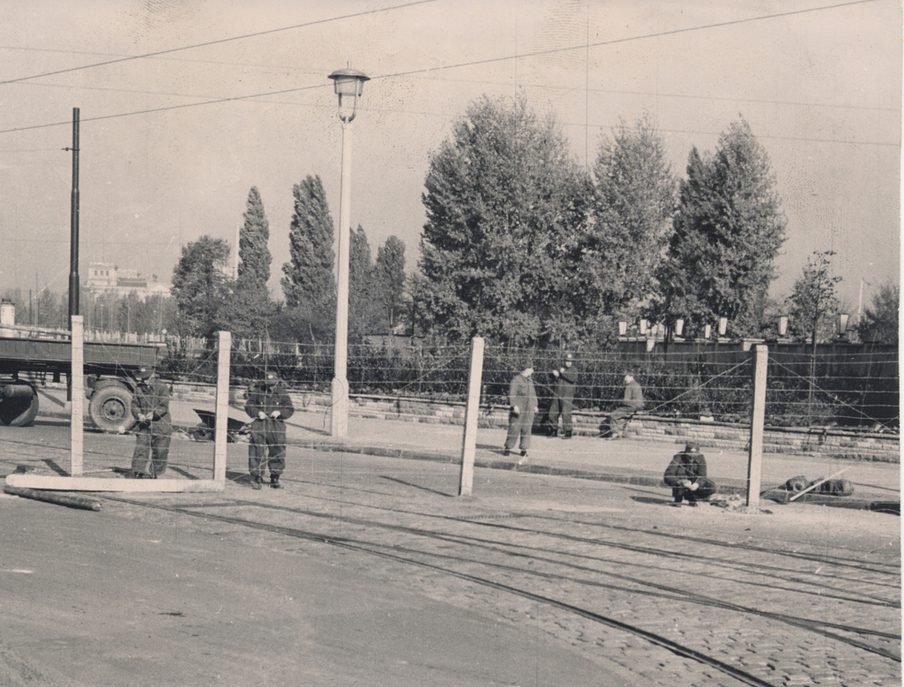 Grenzsoldaten errichten auf einer Fahrbahn Stacheldrahtzäune