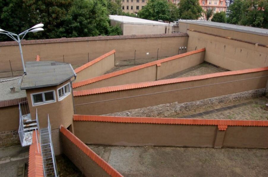 Blick auf Freiganggelände einer Haftanstalt mit Mauern darum